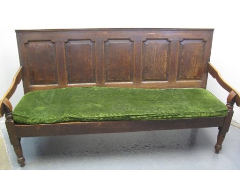EARLY 19TH CENTURY OAK SETTLE, the back with moulded cresting over five cross banded, raised and fielded panels, loose cushio