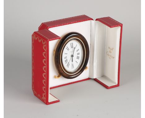 Cartier desk clock, oval model, gilded mechanical clock with a brown edge, slightly damaged.&nbsp;In original box.&nbsp;7509 