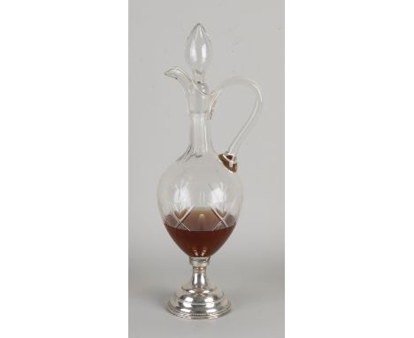 Crystal decanter on round silver base with pearl rim, 835/000.&nbsp;The carafe is equipped with a pouring spout and handle.&n