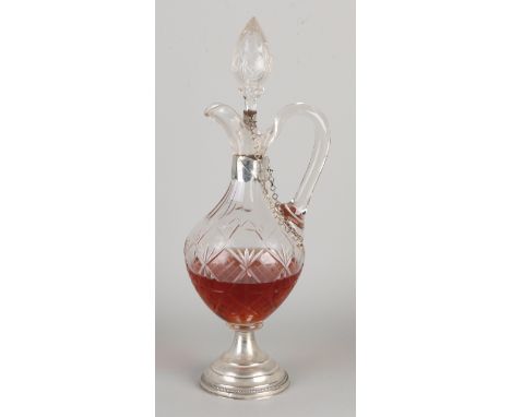 Crystal pouring decanter decorated with cut, placed on a round silver base, with silver mount on the neck with chain attached