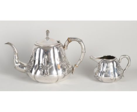 Chinese silver teapot with jug, 900/000, with Chinese figures and flowers.&nbsp;The handles have a bamboo decor.&nbsp;Wing Na