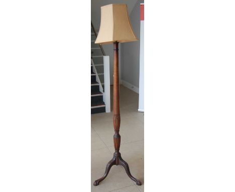 A mahogany standard lamp, raised on floral carved supports, with shade, overall h.185cm