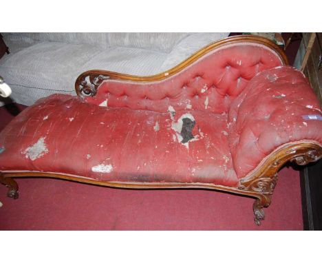 A mid-Victorian carved walnut framed button chaise-longue, with raised and pierced floral scroll decoration, to conforming ac