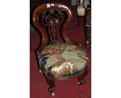 An early Victorian mahogany balloon back and pierced floral carved splatback nursing chair, having floral tapestry upholstere