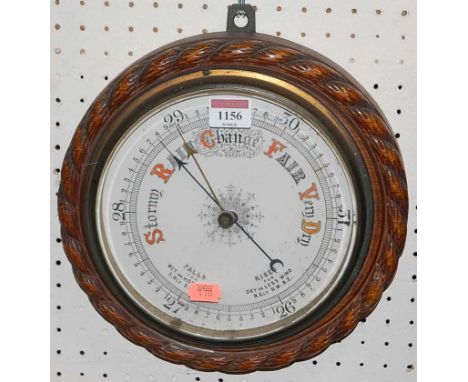 A 1920s oak ropetwist framed circular single dial aneroid barometer, dia.26cm