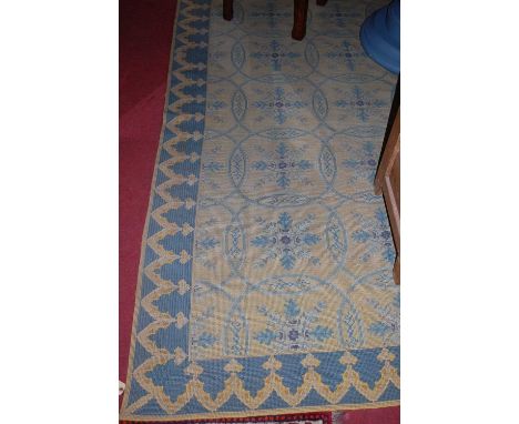 A large European machine woven rug, decorated with floral motifs within roundels, 350 x 260cm; together with a matching hall 