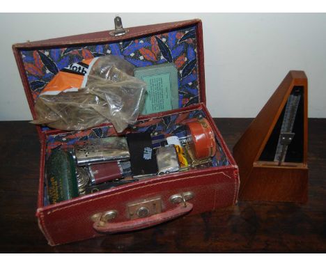 A vintage suitcase containing a quantity of various table lighters, razors etc; together with a metronome 