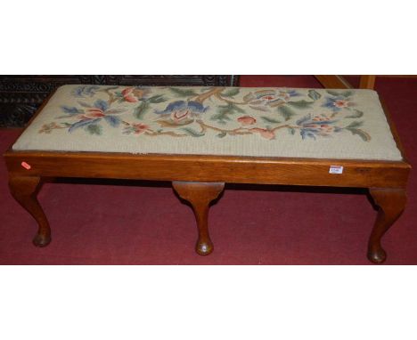 An early 20th century oak and tapestry embroidered double stool, raised on cabriole supports, length 107cm