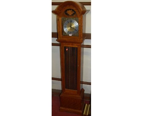 A contemporary hardwood grandmother clock, having silver and brass dial, with three train weight driven movement, having glaz