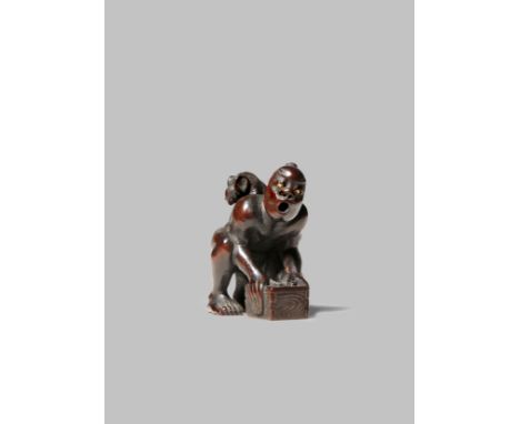 A JAPANESE WOOD NETSUKE OF A THWARTED RAT CATCHER MEIJI 1868-1912 The man kneeling down and holding a box before him, his mou