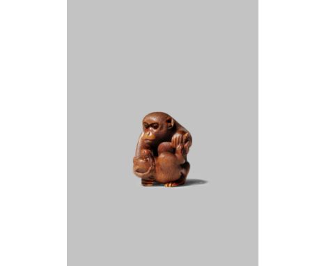A JAPANESE WOOD NETSUKE MEIJI 1868-1912 Carved as a monkey tenderly holding her young before her, their hair finely rendered 