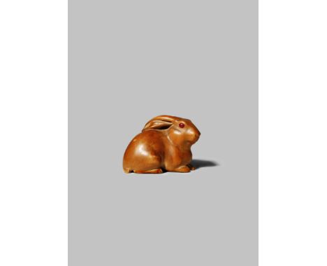 A JAPANESE WOOD NETSUKE 19TH/20TH CENTURY Carved as a rabbit, the small mammal resting on a reishi fungus, with long ears and