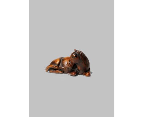 A JAPANESE WOOD NETSUKE OF A HORSE EDO/MEIJI PERIOD Lying with its head turned to the side and the legs tucked underneath its