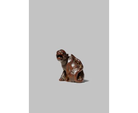 A JAPANESE WOOD NETSUKE OF A TIGER EDO/MEIJI PERIOD The feline seated on its haunches, with the head turned and baring its te