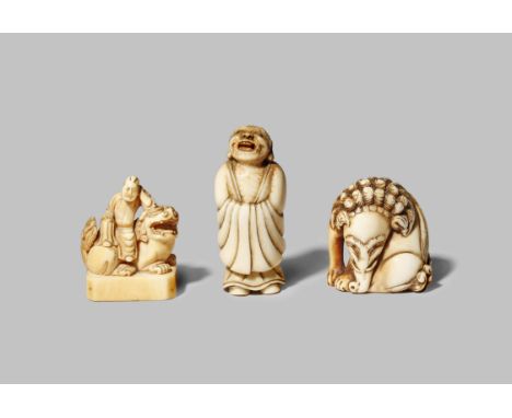 THREE JAPANESE NETSUKE EDO/MEIJI PERIODS Two in ivory, one carved as a seated baku, with a long curling mane and its head low