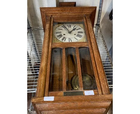A vintage wooden cased brass dialled wall clock with pendulum and key, shipping unavailable 