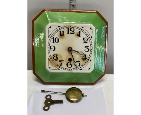 An art deco period ceramic faced wall clock with pendulum and key 