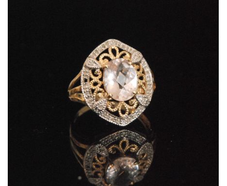 A 9ct modern rose quartz and diamond cluster ring, central oval claw set quartz within pierced head and diamond border, ring 