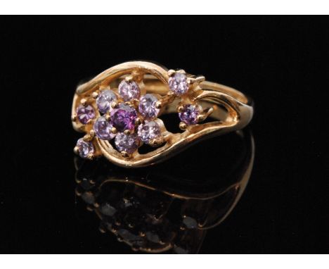 A modern 9ct hallmarked amethyst cluster ring, seven stone cluster within pierced head flanked by two further stones to each 