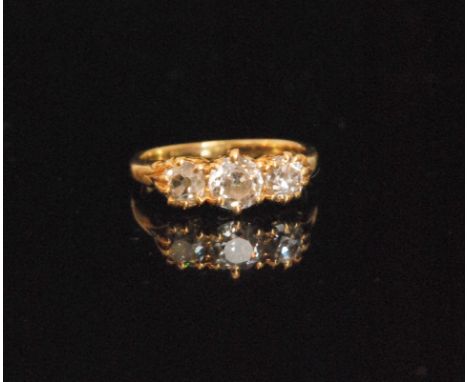 A late Victorian 18ct three stone diamond ring, the central old brilliant cut diamond between two smaller old brilliant cut d