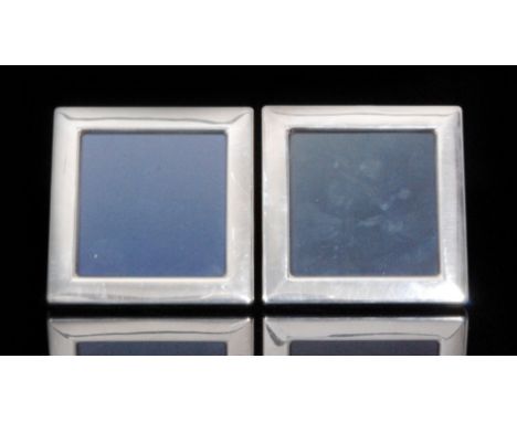 A pair of modern hallmarked silver photograph frames each of plain square form with blue velvet easel back, Sheffield 1983 (2