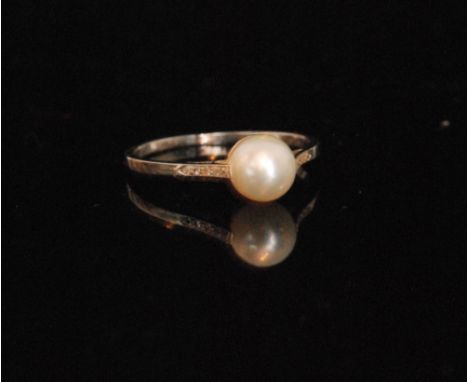 An 18ct white gold cultured pearl and diamond ring, central pearl to five stone diamond set shoulders, ring size Q 1/2. 