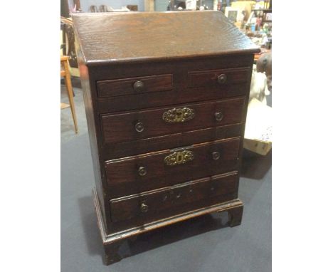 A George III oak apprentice chest fitted with two short and three long drawers below a sloping top on bracket width 29cm