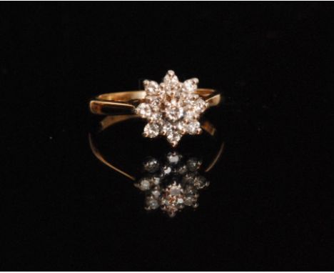 A later 20th Century 9ct hallmarked diamond cluster ring individually claw set stones to a stepped flower head design, ring s