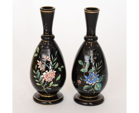 A pair of late 19th Century French black glass vases of footed tapered form with a ringed and flared collar neck, enamel deco