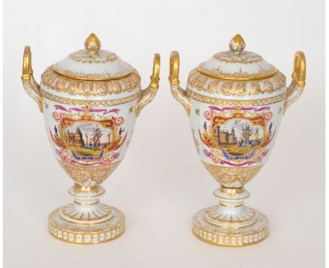 A pair of 20th Century twin handled vase and covers each decorated with a hand painted seascape cartouche within elaborate bo