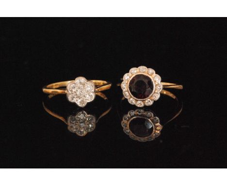 An 18ct diamond flower head ring, stamped, ring size O, together with a garnet and diamond ring, the circular cut garnet coll