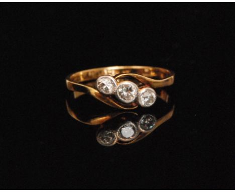 An early 20th Century 18ct diamond three stone ring, collar set brilliant cut stones set on a slight twist, ring size Q. 