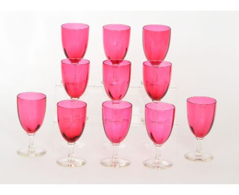 A set of eleven late 19th to early 20th Century wine glasses with a fluted ruby glass bowl raised to a plain clear crystal st