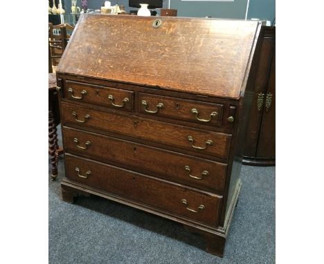 An 18th Century oak and mahogany cross-banded fall-front bureau, with fitted interior above two short and three long drawers 