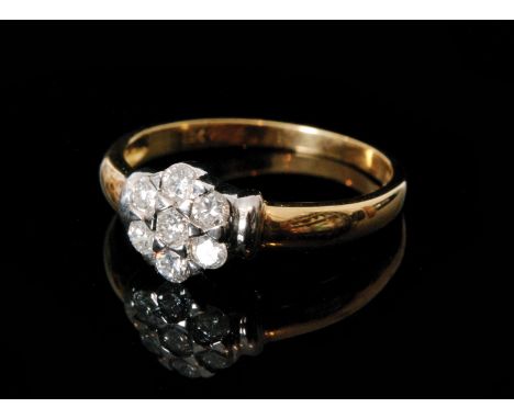 A modern 18ct hallmarked diamond daisy cluster ring seven brilliant cut claw set stones to white gold detailed shoulders, rin