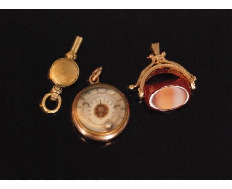 A 9ct gold carnelian swivel fob together with a yellow metal watch key and a rose gold coloured compass fob with carnelian ba