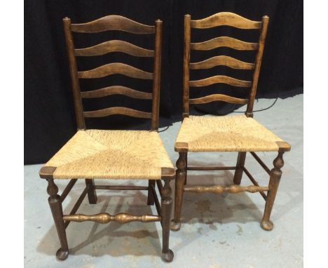 A set of eight beech ladder back rush seat dining chairs on turned legs and stretchers terminating in splayed pad feet (8)