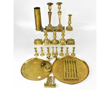 A mixed lot of brassware, to include two Celtic decorated trays, various candlesticks, a shell case, etc.