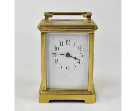 A French brass carriage clock, the enamelled dial set with Arabic numerals, indistinct retailer's mark to face, in a plain ca