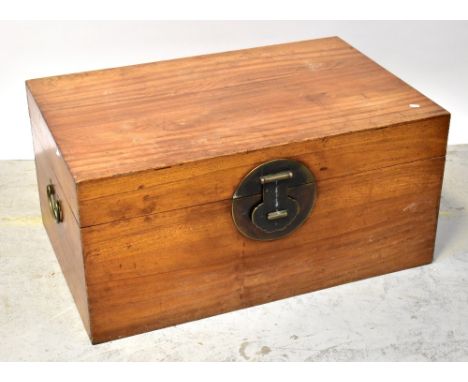 A large Chinese-style chest, the hinged lid secured by a large brass circular locking mechanism to the front and further drop
