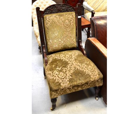 A Victorian walnut-framed salon chair, the carved top rail above upholstered back and seat, raised on ring turned supports to