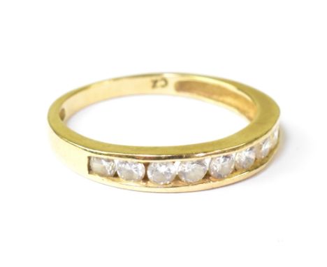 A modern 9ct gold half eternity ring with a row of pavé set cubic zirconia stones, on a yellow 9ct gold shank, size P, approx