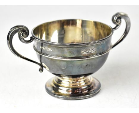 An Edwardian silver twin-handled trophy of squat form with scroll handles, initialed 'CME', Harrison Bros &amp; Howson, Sheff