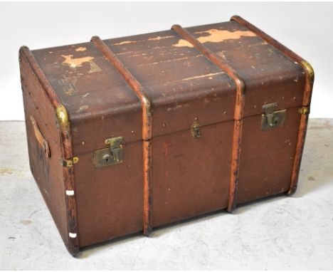 A large early 20th century canvas travel trunk with wood and brass laths, initialled to side, with leather carrying handles, 