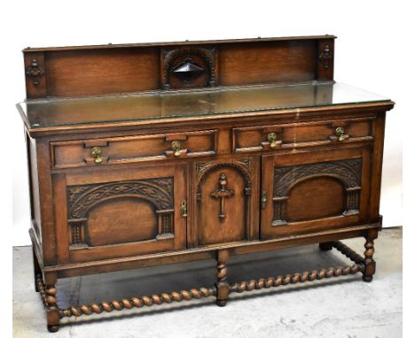 A Victorian oak sideboard, the raised back centred with a carved arch around a lozenge-shaped motif, above a base of two long