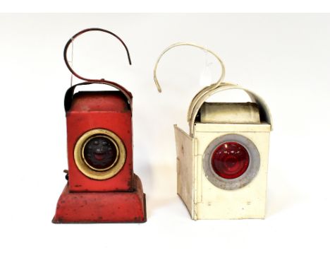 Four early 20th century railway lanterns to include a red Akenco lamp, a C &amp; K white painted lamp and two others (4).