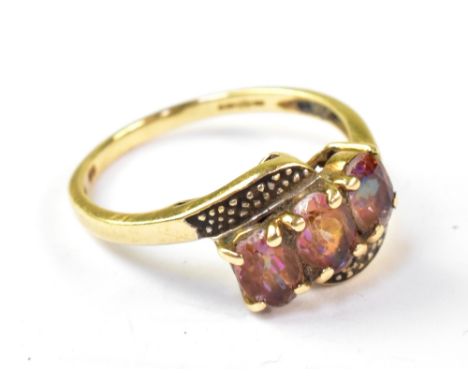 A modern 9ct gold crossover ring, with three inset pink stones with rainbow hue, on a modern 9ct gold shank, size P, approx 2