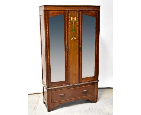 An Edwardian Art Nouveau mahogany twin mirror door wardrobe, central panel with Art Nouveau floral design, string inlay throu