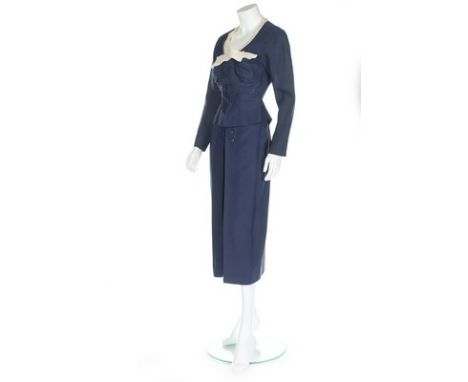 A Jacques Fath couture navy wool day suit, circa 1950, labelled to the jacket, with white organza neckline edging with bow, r