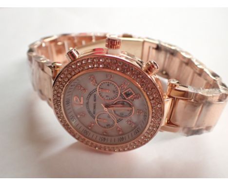 Michael Kors mother of pearl faced wristwatch on a plated bracelet CONDITION REPORT: This item is working at lotting up.